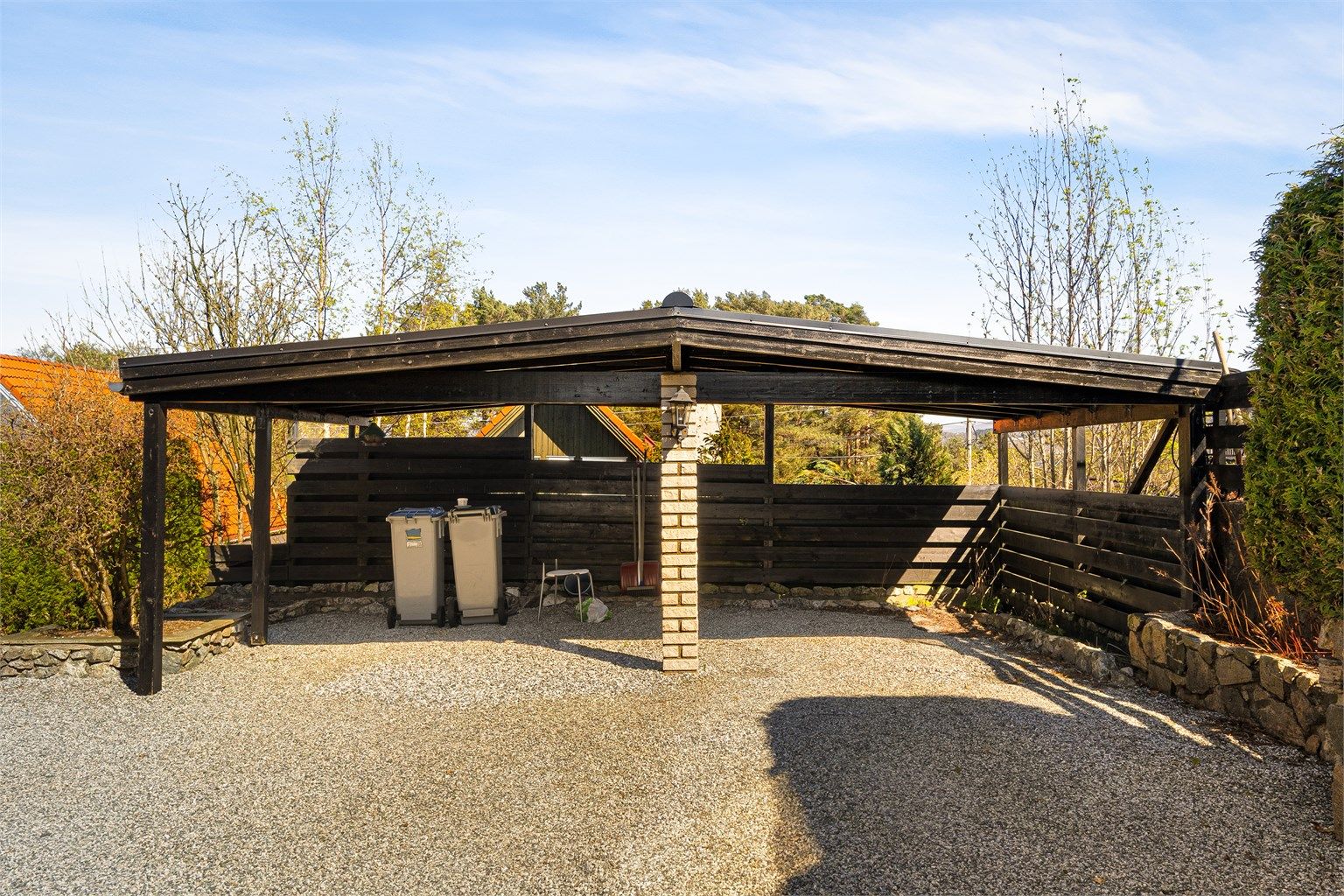 God parkering på eiendommen med dobbel carport og plass til flere biler i innkjørselen.
