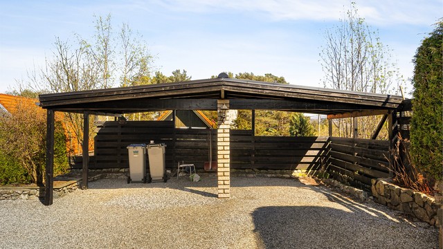 God parkering på eiendommen med dobbel carport og plass til flere biler i innkjørselen.