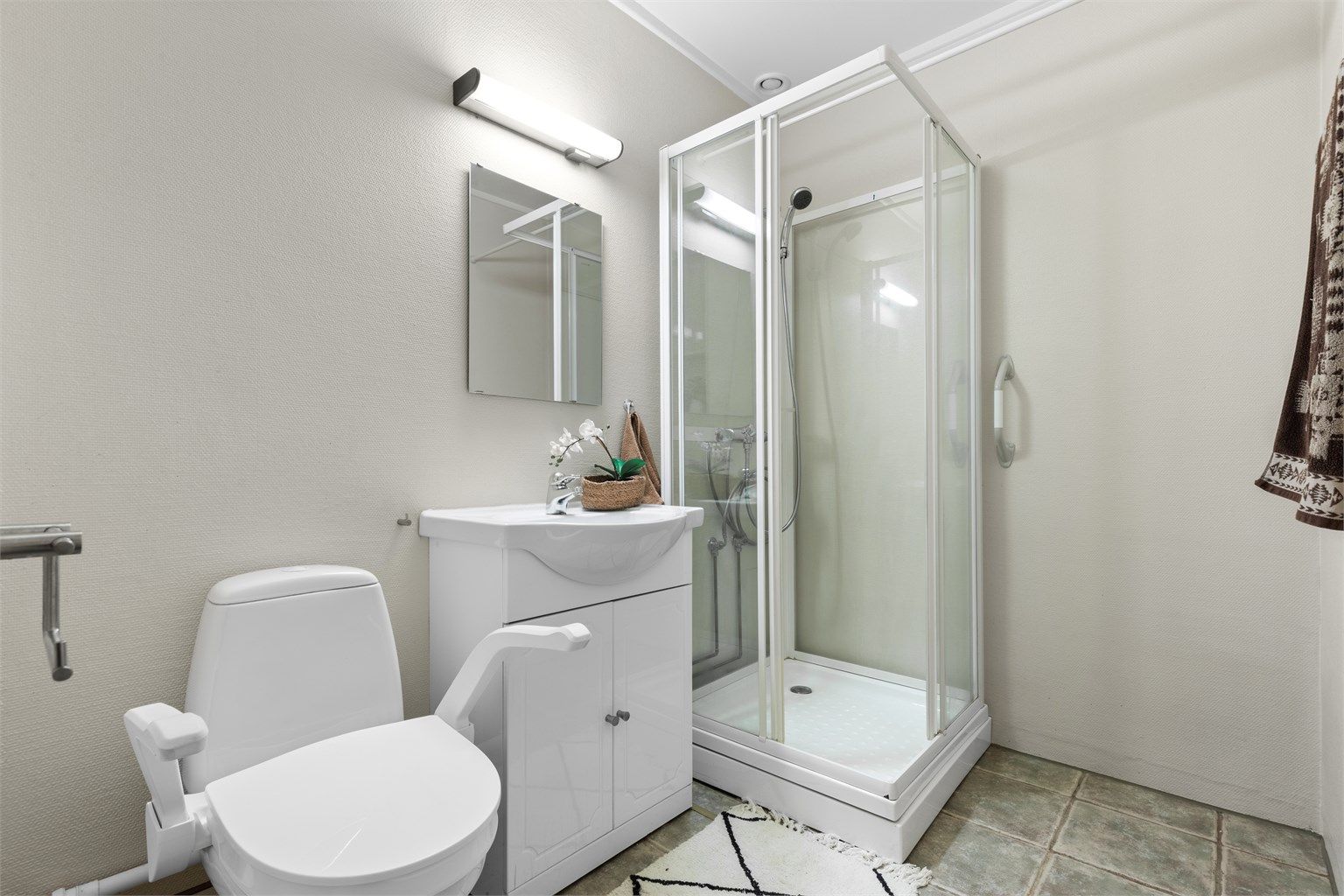 Bad - flislagt gulv med gulvvarme - servant med underskap og speil