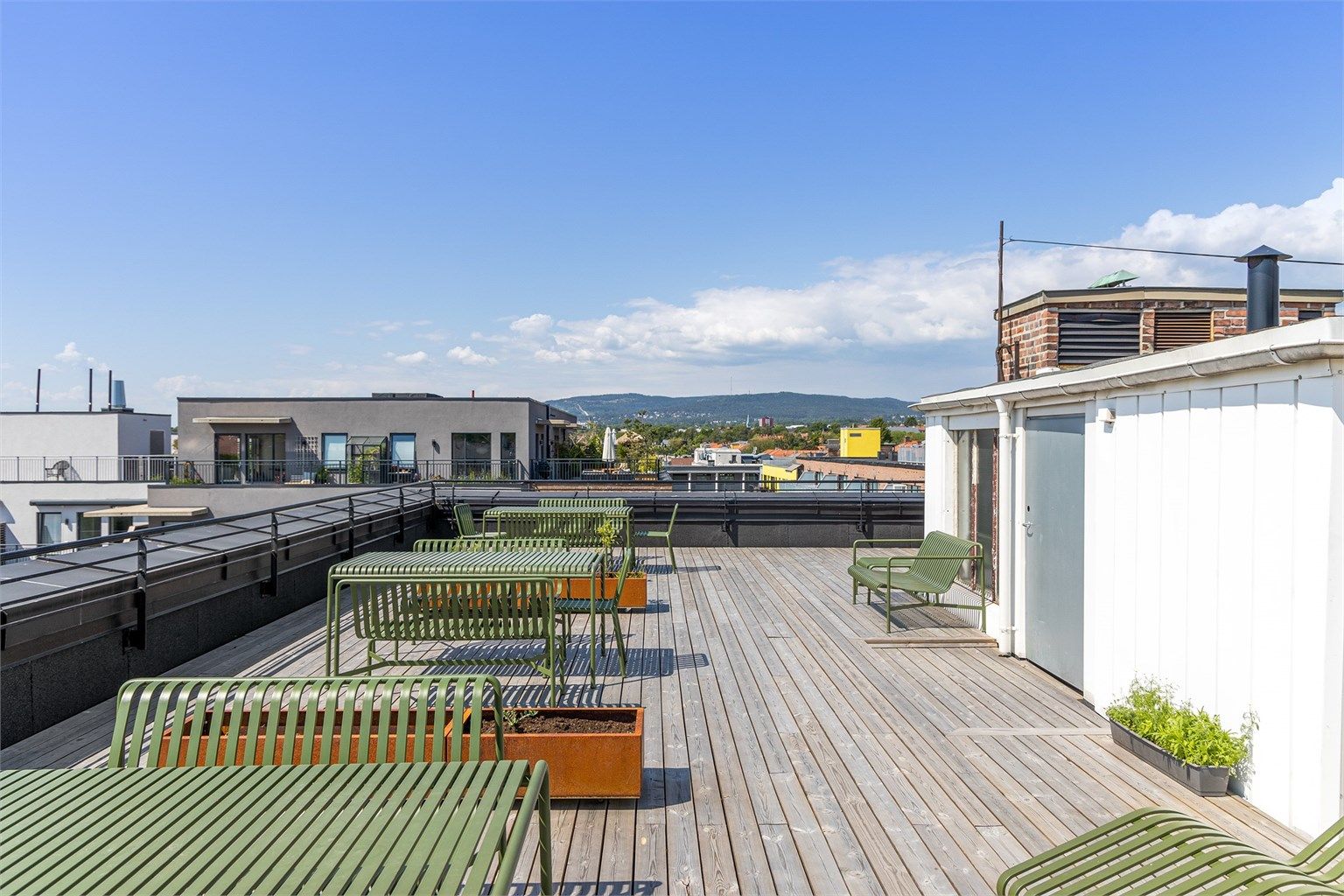 Takterrassen er møblert med sittegrupper og gassgrill, tilgjengelig for alle beboere. Solforholdene her oppe er upåklagelige!