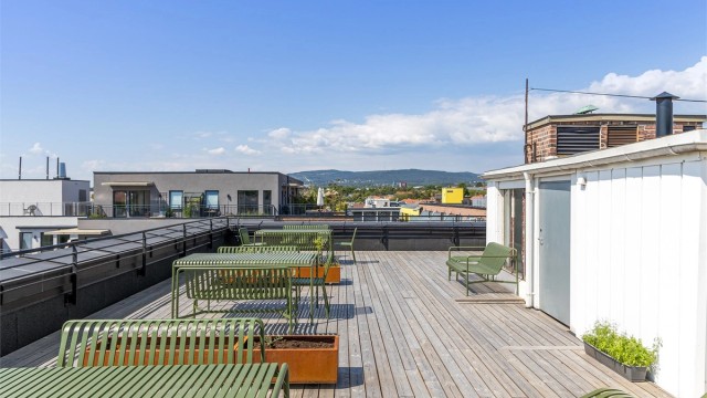 Takterrassen er møblert med sittegrupper og gassgrill, tilgjengelig for alle beboere. Solforholdene her oppe er upåklagelige!