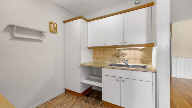 Kjøkkeninnredning fra byggeåret med laminert benkeplate og fliser over benken.