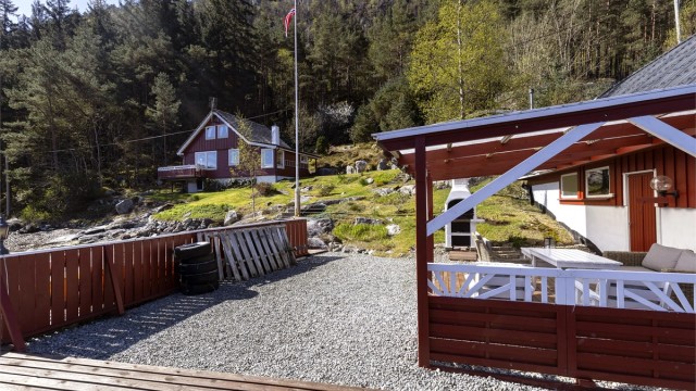 Utsikt fra bryggen mot hovedhytta og det omkringliggende terrenget.