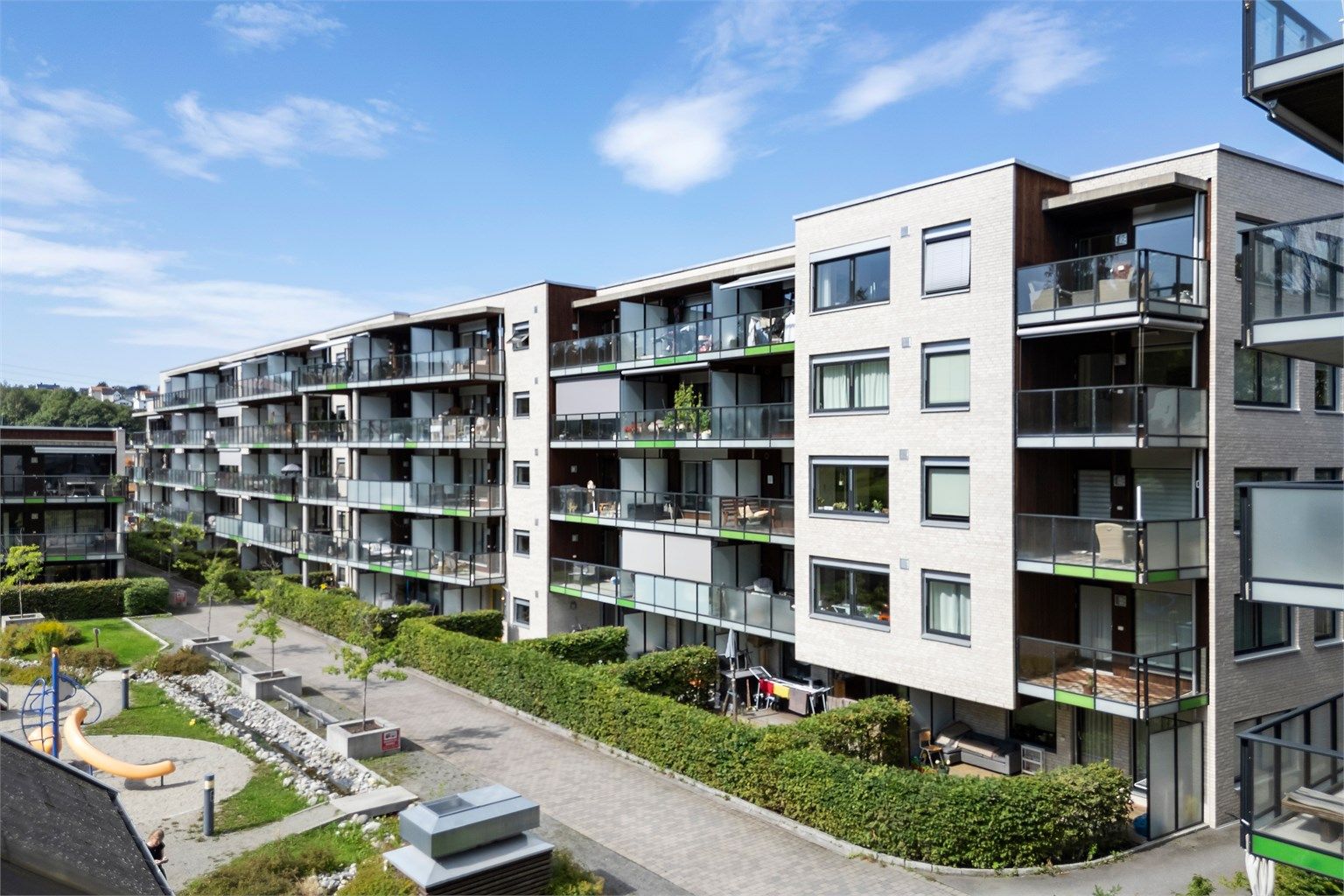 Fasade + flott felles hage og lekeplass.