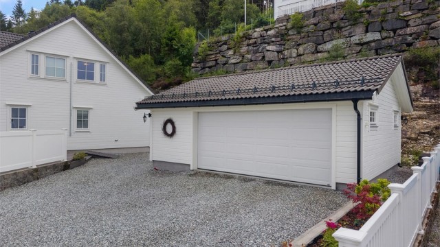 Stor dobbel garasje på 43 kvm. med automatisk leddport samt sidedør. I tillegg er det gode parkeringsmuligheter på tomten.