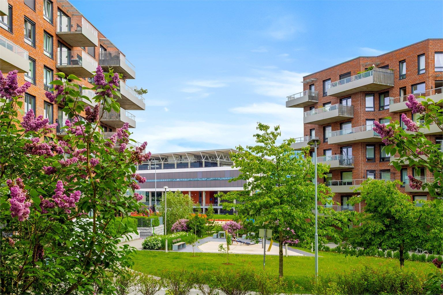 Pent opparbeidede fellesområder med grønne plenarealer, beplantning og lekeplass skaper et hyggelig og familievennlig bomiljø.