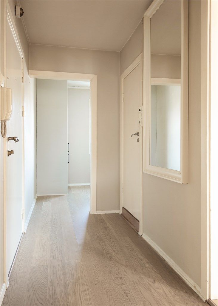 En lys entré ønsker velkommen inn, med parkett på gulvet som går igjen i stuen.