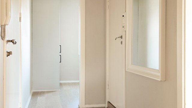 En lys entré ønsker velkommen inn, med parkett på gulvet som går igjen i stuen.