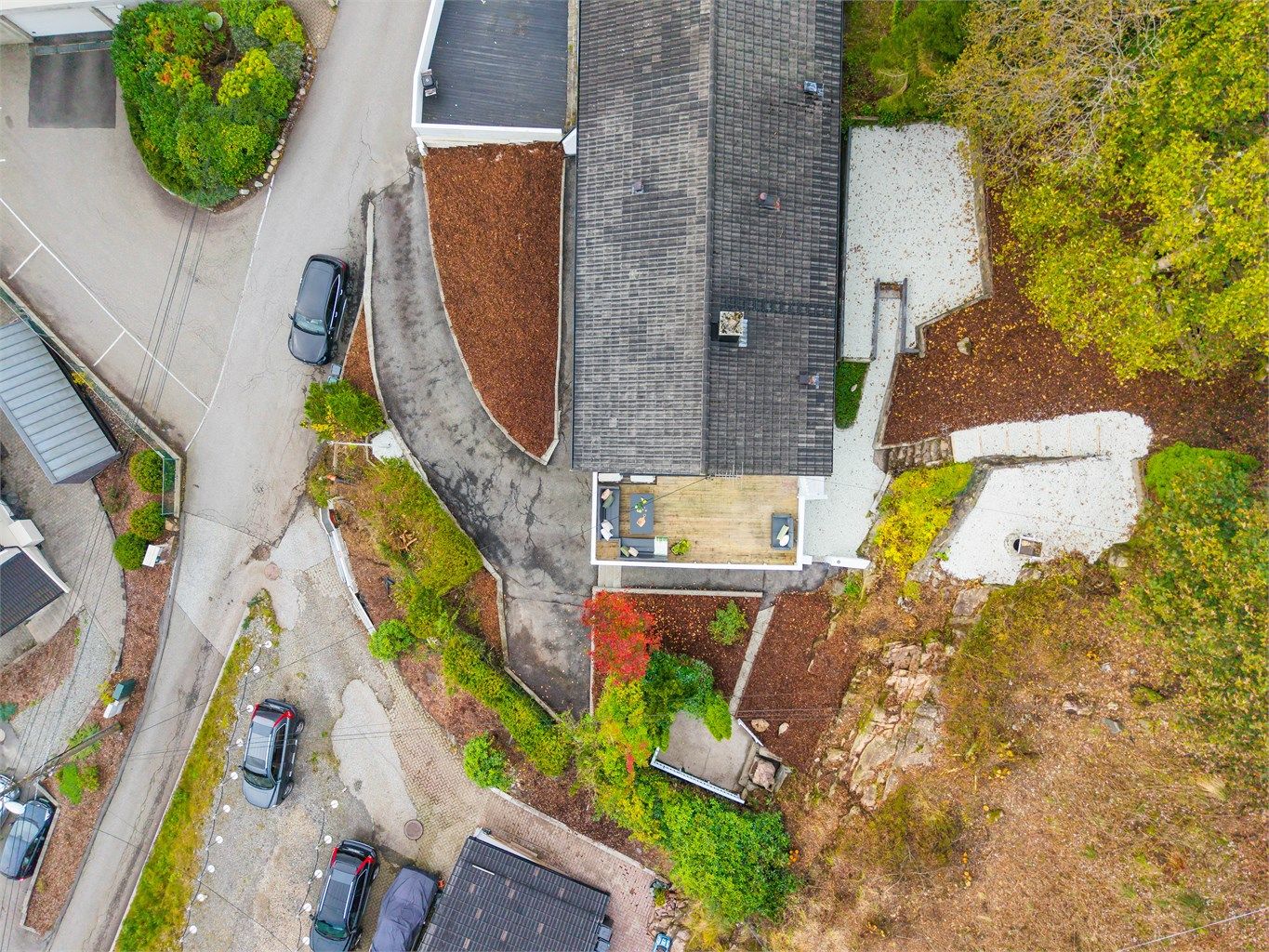 Tomten er opparbeidet med terrasse, beplantning, forstøtningsmurer og asfaltert gårdsplass. Ny singel lagt i oktober 2026.