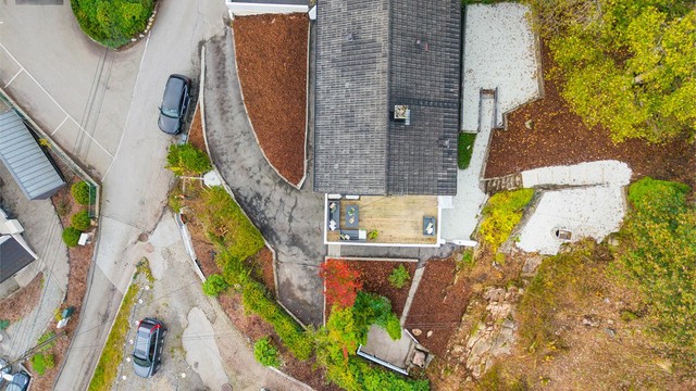 Tomten er opparbeidet med terrasse, beplantning, forstøtningsmurer og asfaltert gårdsplass. Ny singel lagt i oktober 2026.