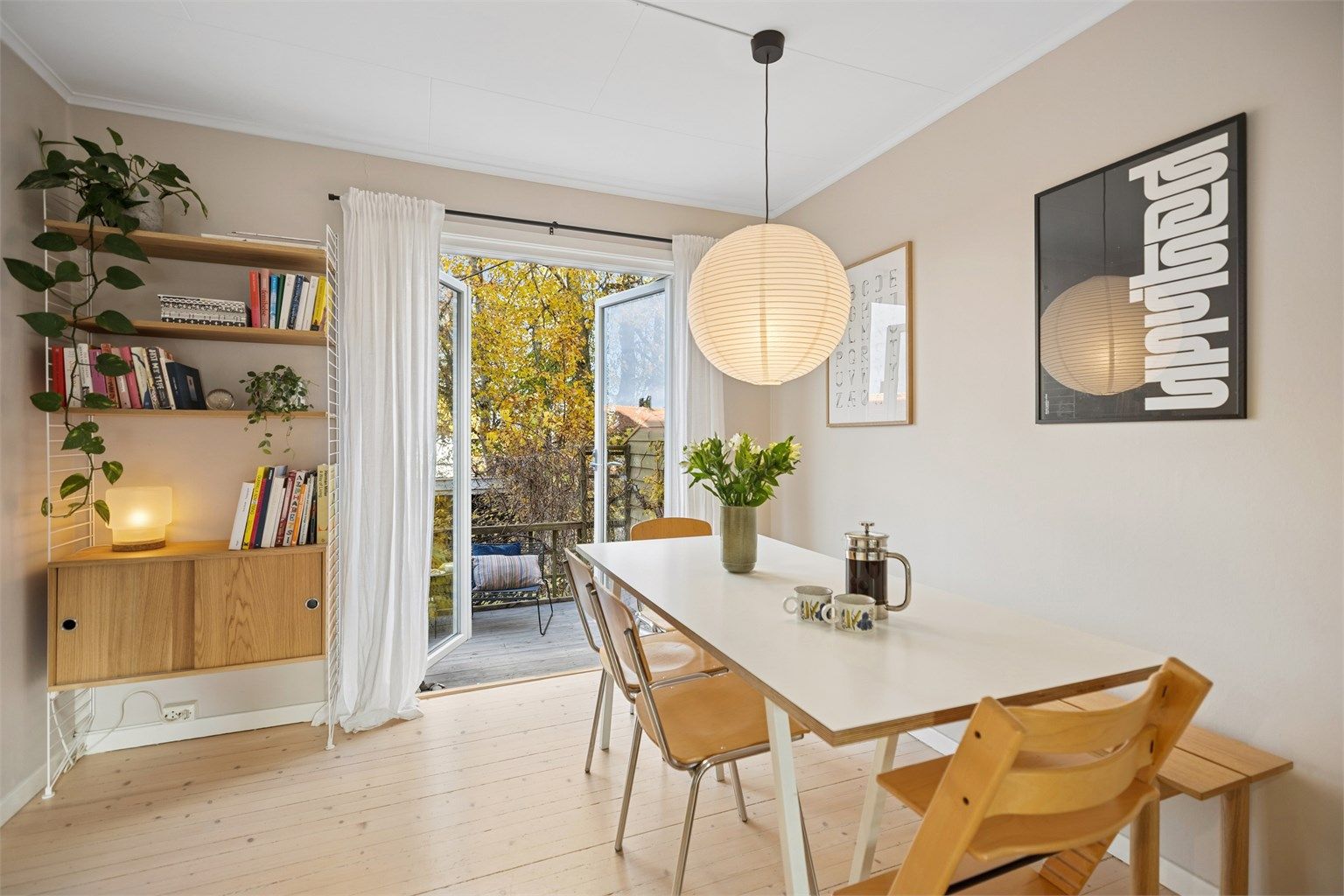 Hyggelig og luftig spisestue med utgang til balkong - Terrassedøren i glass inviterer deg ut og omgivelsene inn.