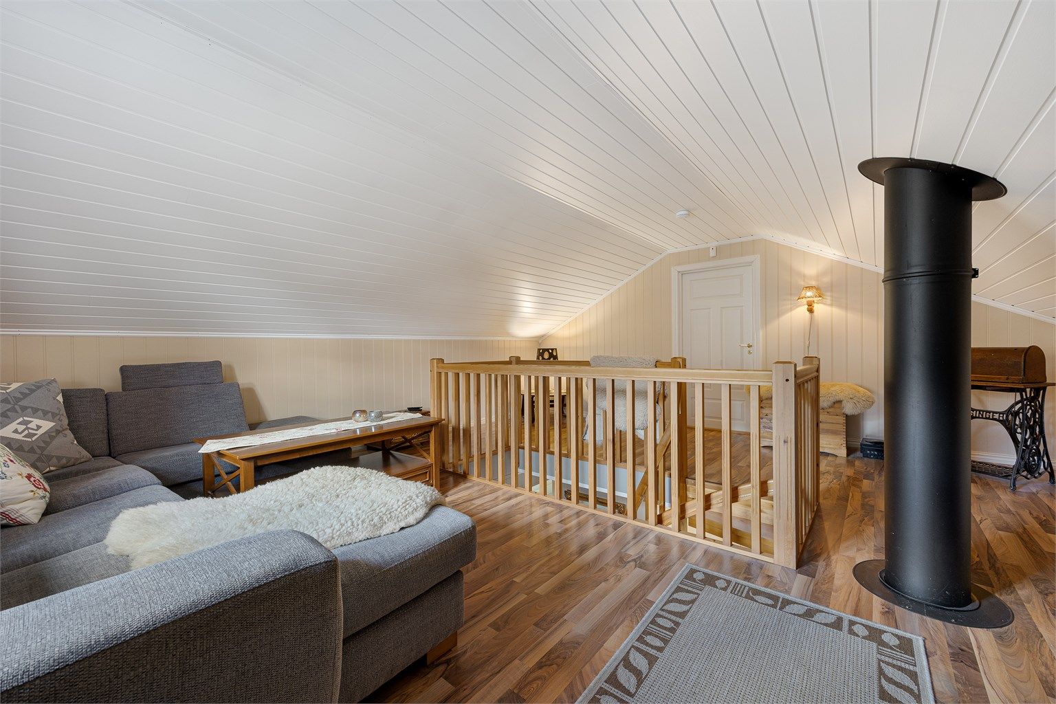 Loftstuen gir ekstra areal for familien. Rommet har laminat på gulv og panel på vegger og i himling.