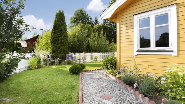 Gangsti av grus og steinheller gjennom den velholdte hagen.