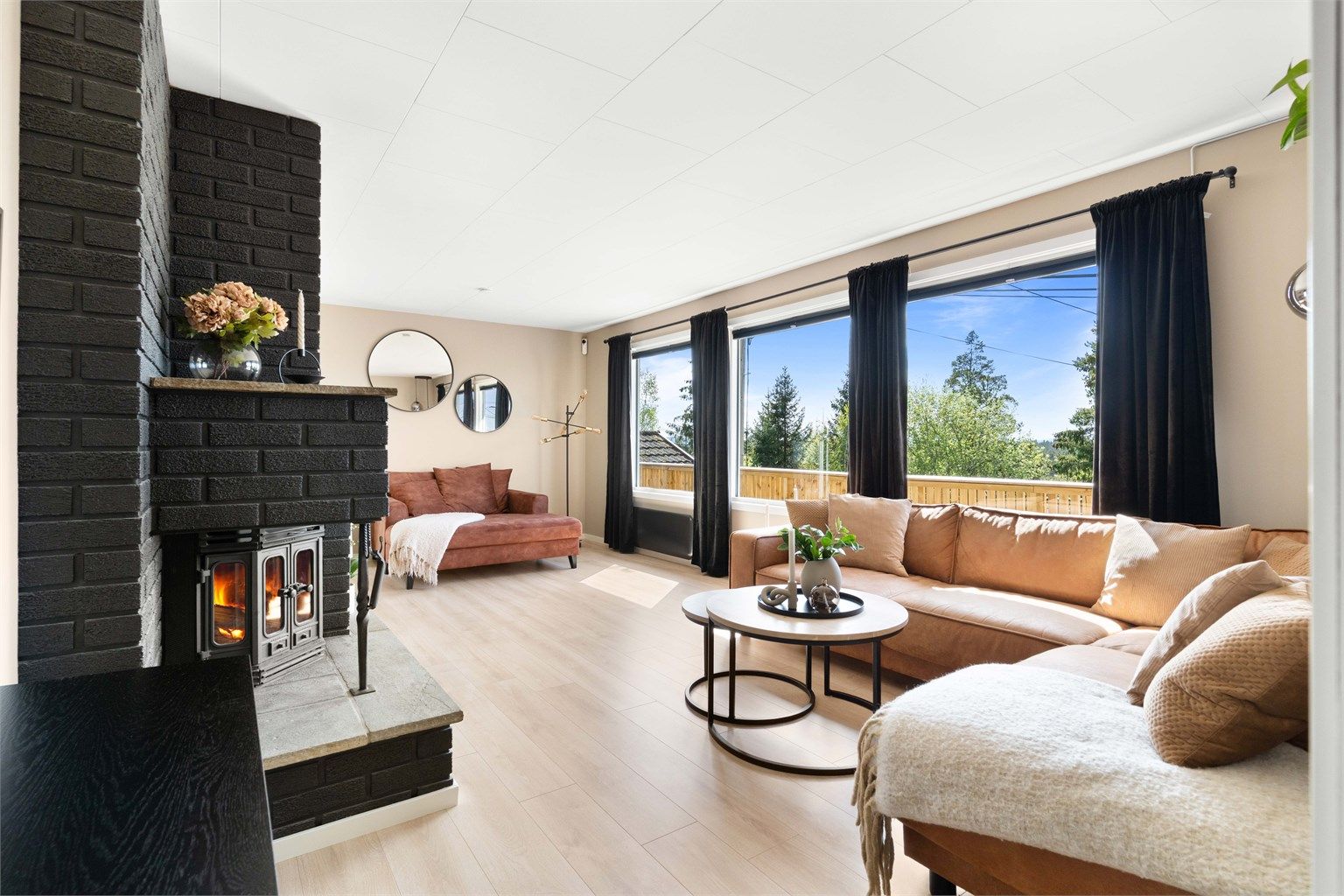 Lys og moderne stue med store vindusflater som slipper inn rikelig med naturlig lys.