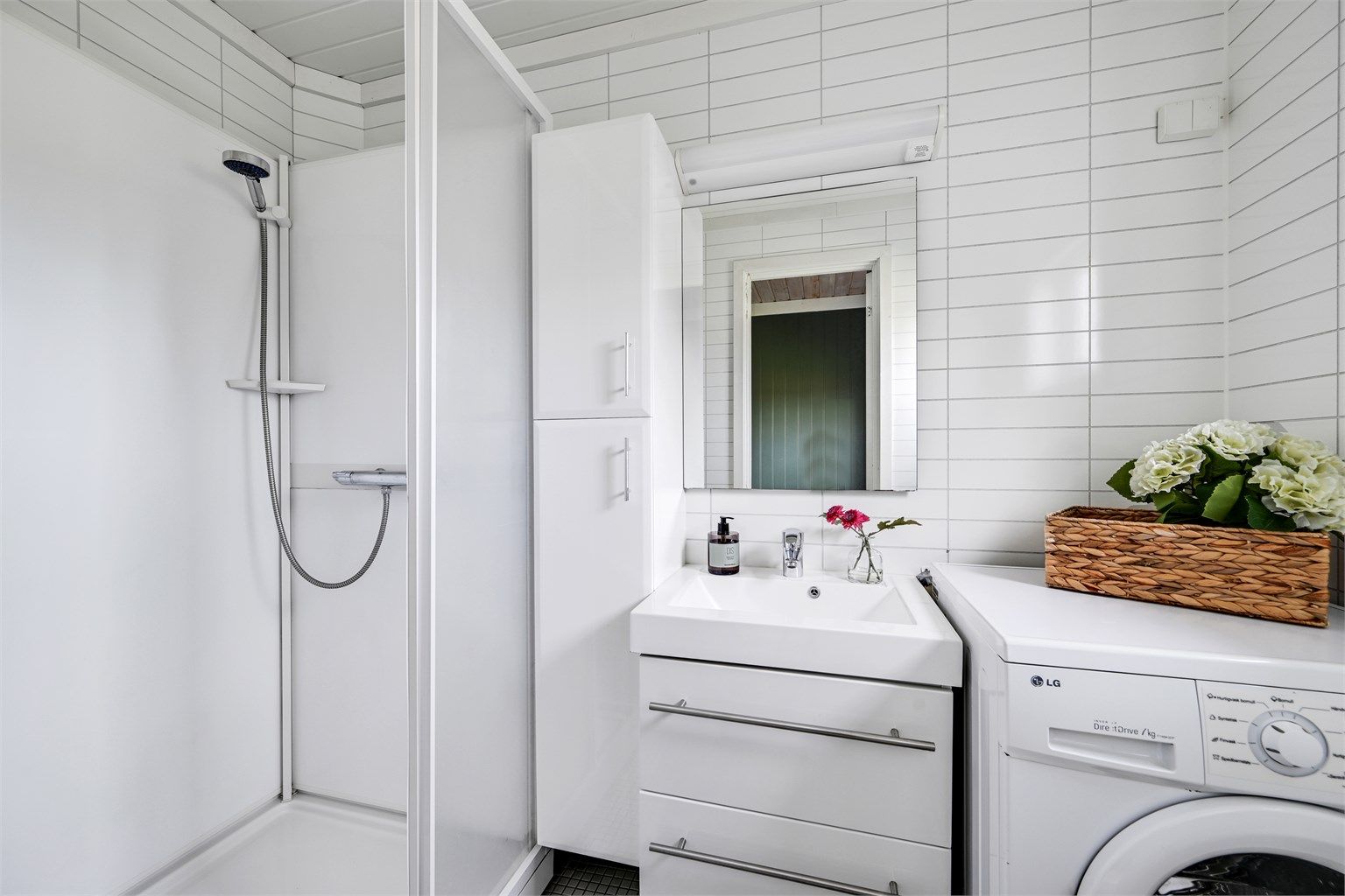 Badet i stallbygningen er utstyrt med dusjkabinett, servant og opplegg for vaskemaskin. 