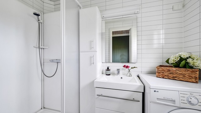Badet i stallbygningen er utstyrt med dusjkabinett, servant og opplegg for vaskemaskin.