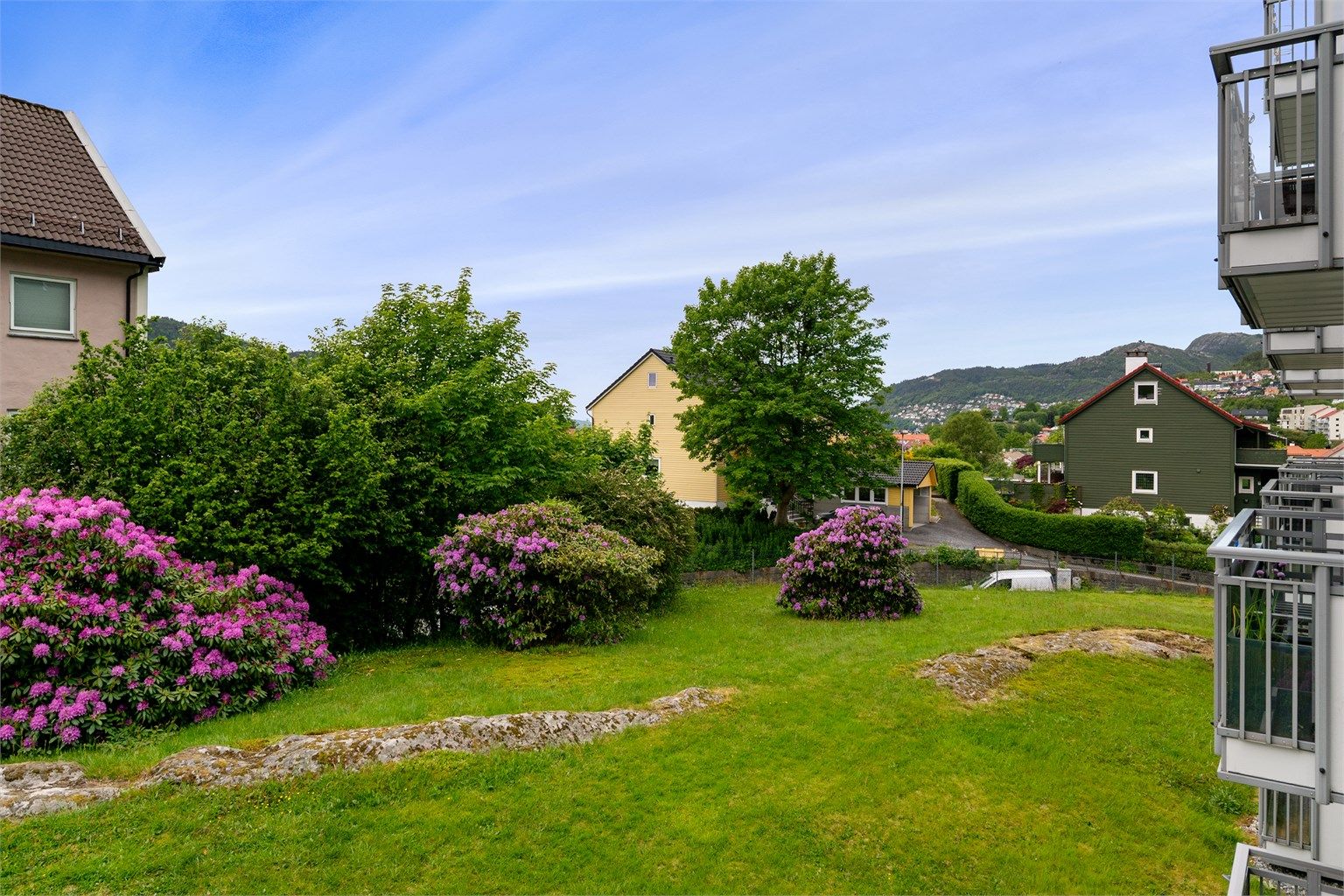- Om sommeren ser uteområdene slik ut. Nydelige farger med flere nydelige rhododendronbusker på borettslagets tomt -