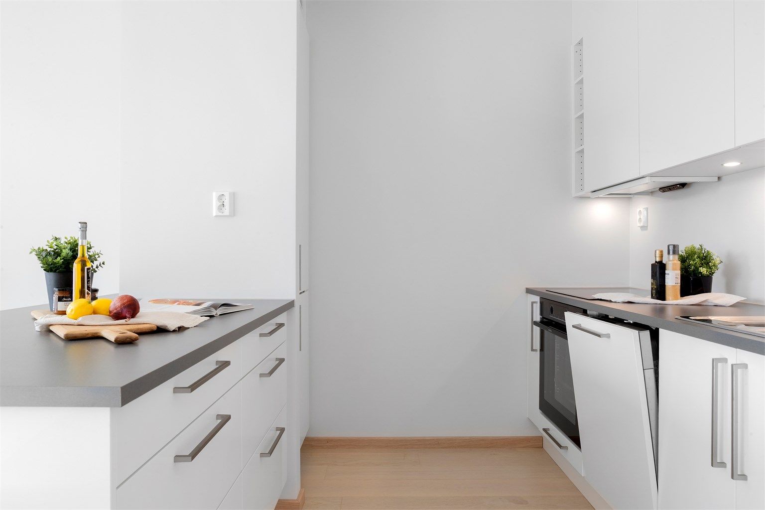 Kjøkkeninnredning fra Sigdal med glatte fronter og laminert benkeplate. Stekeovn, platetopp og oppvaskmaskin er integrert.