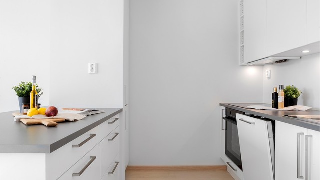 Kjøkkeninnredning fra Sigdal med glatte fronter og laminert benkeplate. Stekeovn, platetopp og oppvaskmaskin er integrert.