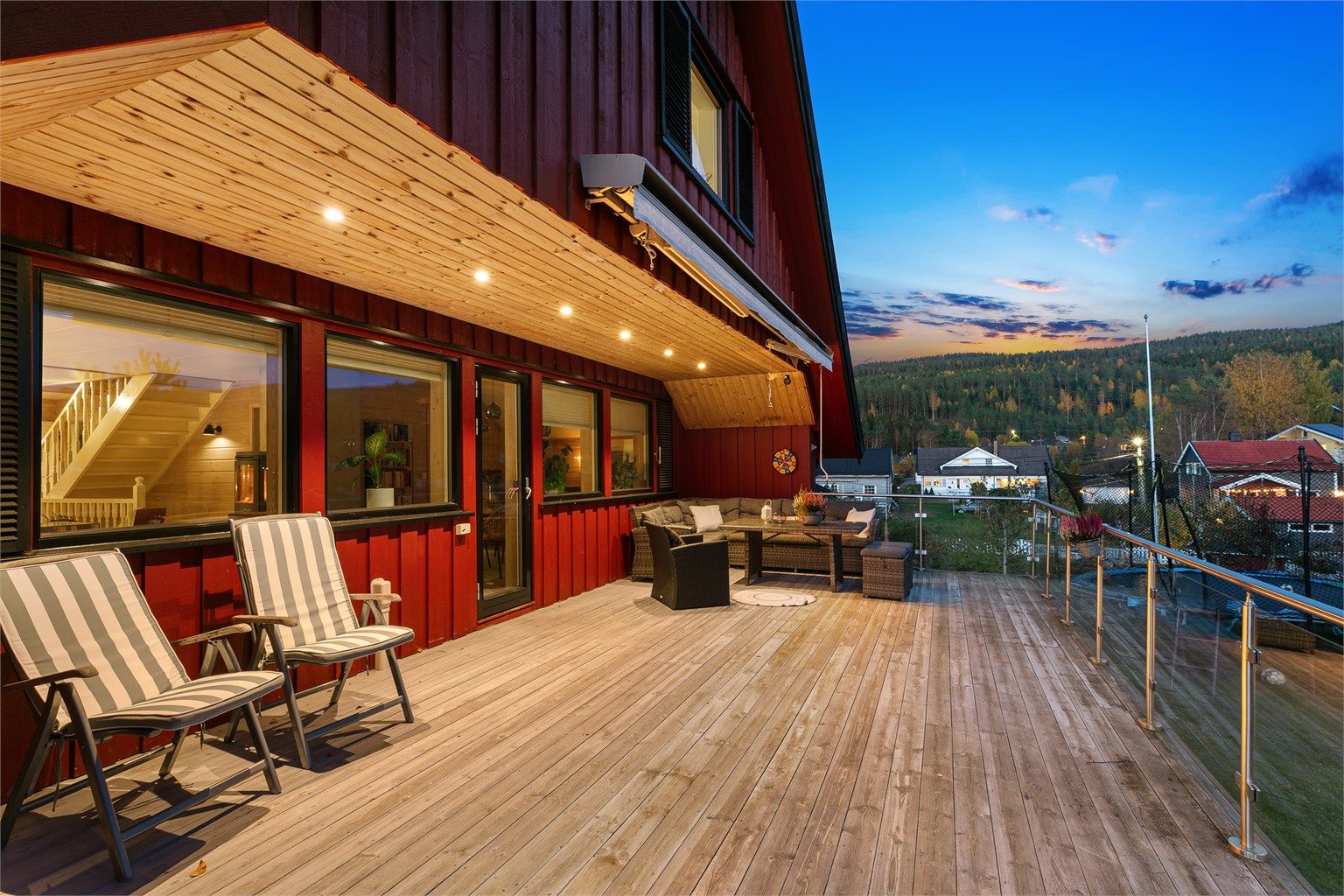 Terrassen er delvis overbygd med downlights, markise og god plass til sittegrupper.