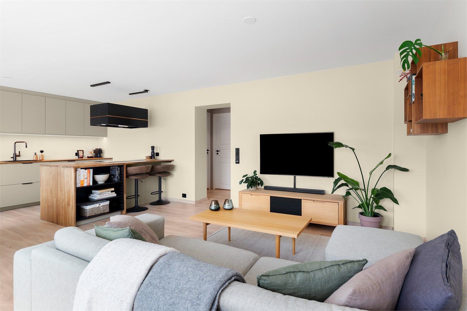 Videre fra gangen kommer man inn et åpent stue-kjøkkenrom på 33m². Det er lagt laminat på gulvflater, malte vegg- og himlingsflater i gips med listefri overgang