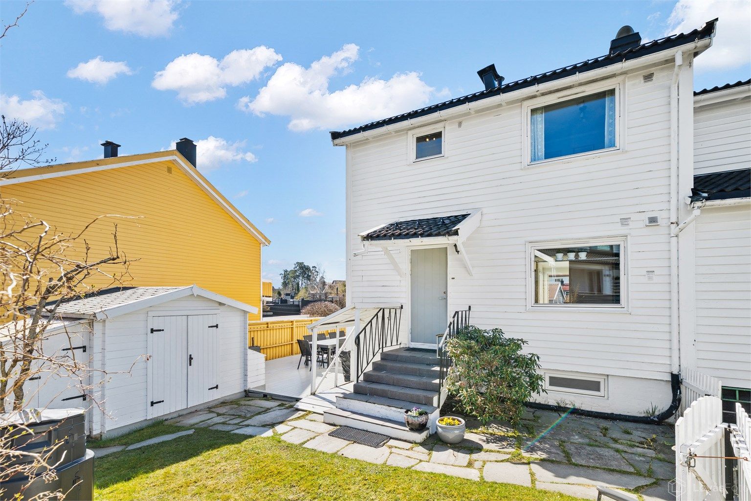 Boligens fasade er kledd med liggende trekledning.