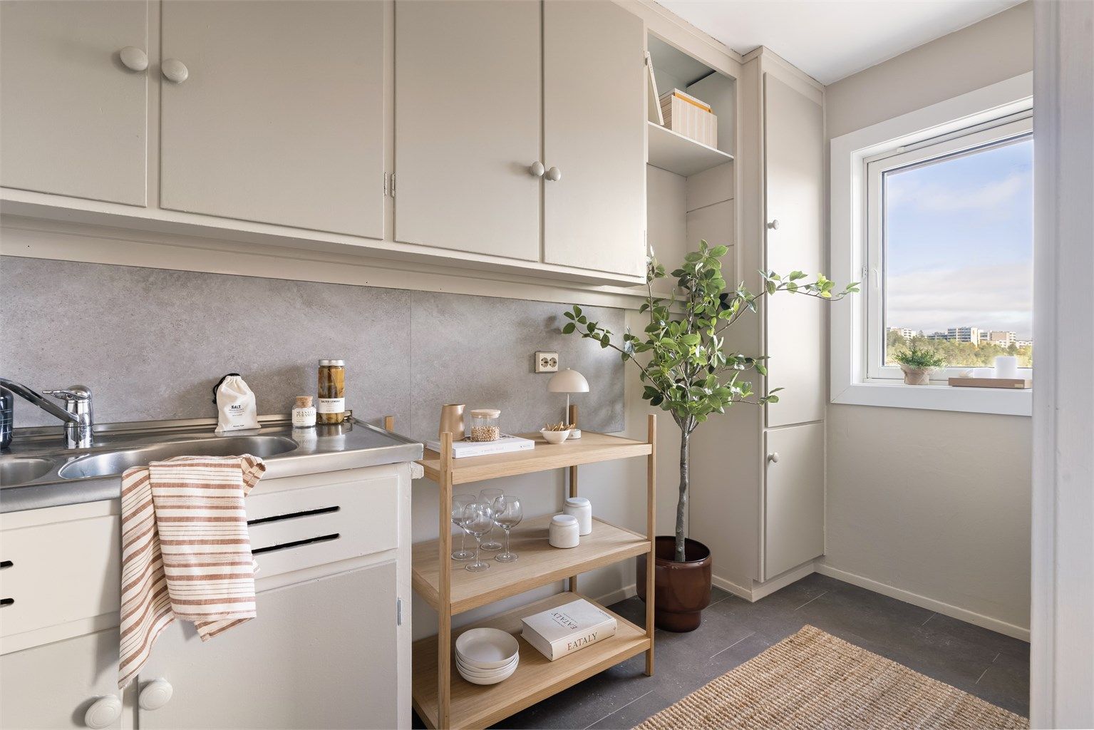 Innredningen har malte fronter og heldekkende benkebeslag med skylle- og oppvaskkum.