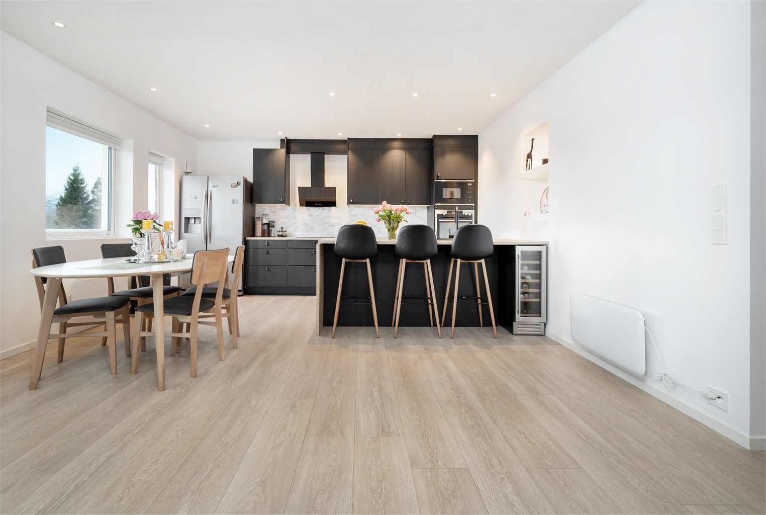 Stuen er i åpen løsning mot kjøkken og det er god plass til spisebord i tilknytning til kjøkken samt sitteplasser ved kjøkkenhalvøy