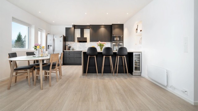 Stuen er i åpen løsning mot kjøkken og det er god plass til spisebord i tilknytning til kjøkken samt sitteplasser ved kjøkkenhalvøy