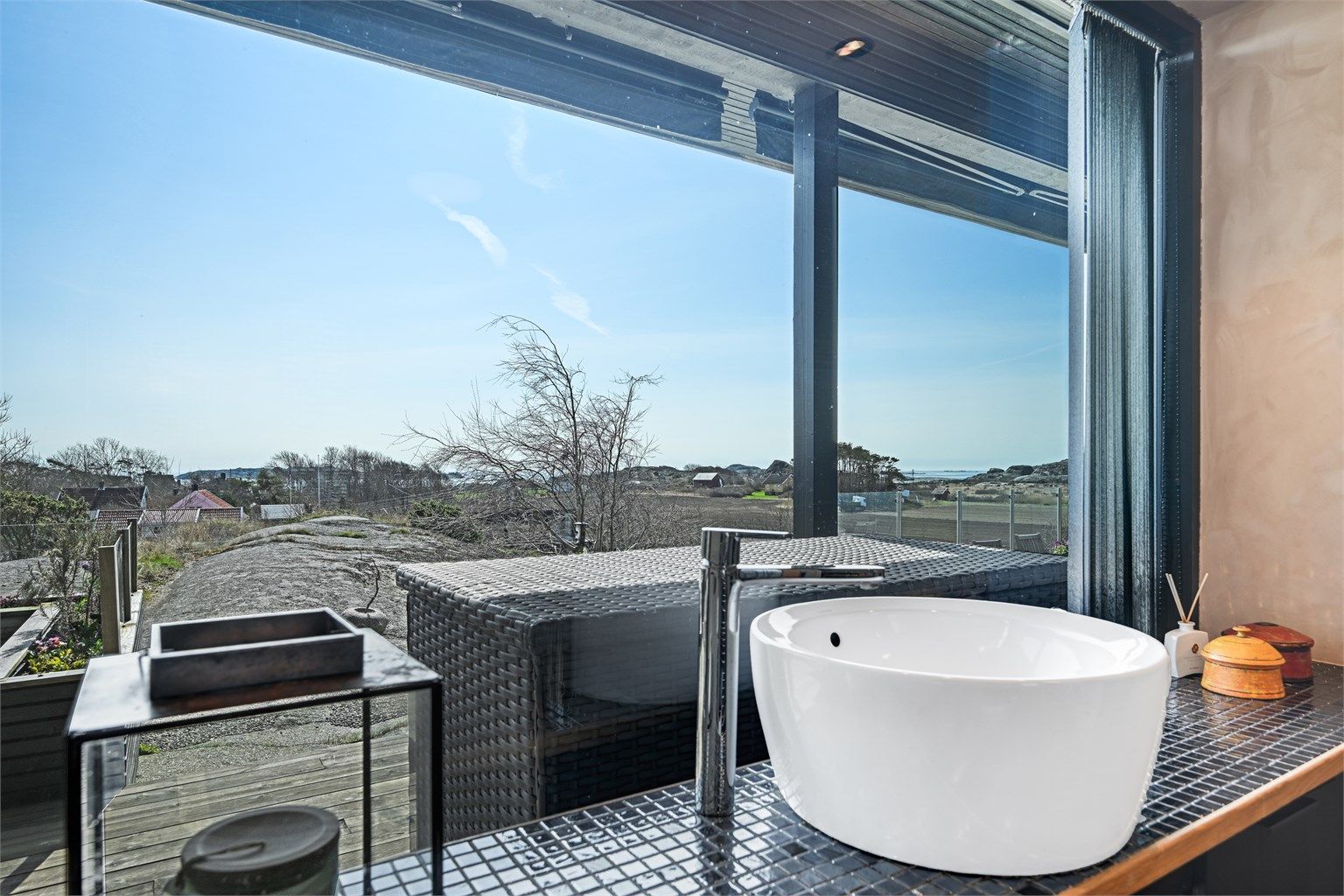 Rommet har en plassbygget innredning med overliggende servant på en flislagt benkeplate