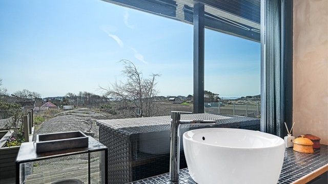 Rommet har en plassbygget innredning med overliggende servant på en flislagt benkeplate