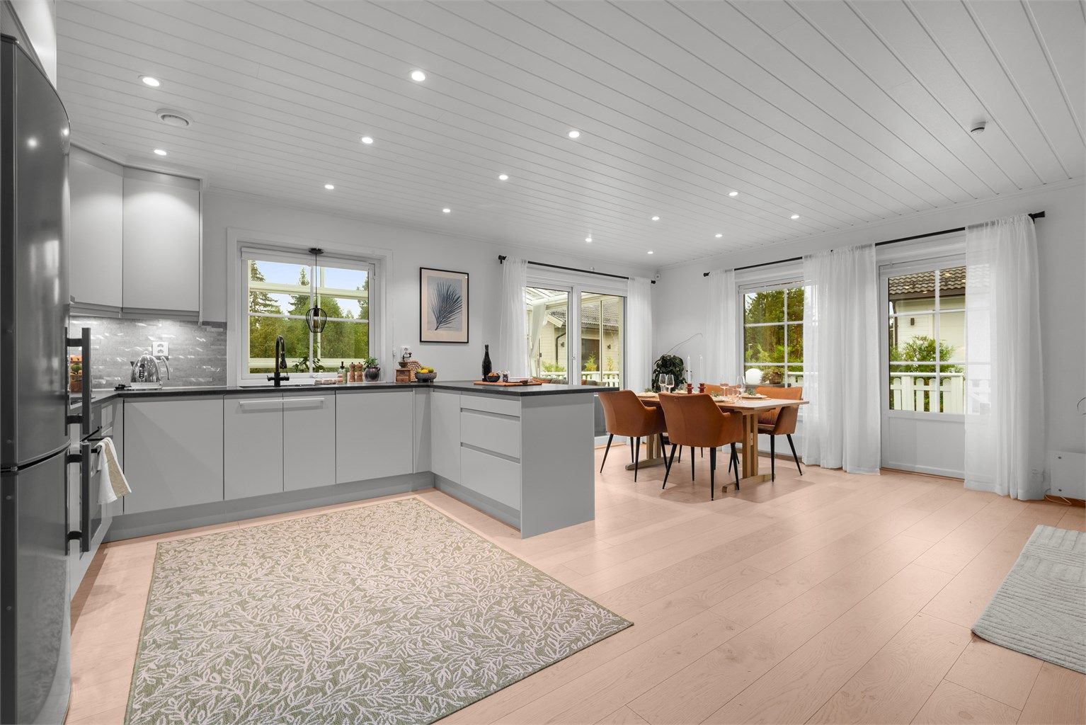 Gulvflater med parkett og store vinduer som slipper inn mye naturlig lys