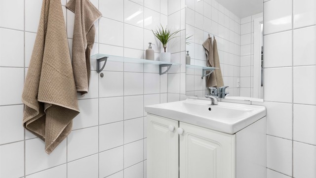 Vegghengt servantinnredning med speil og integrert belysning.