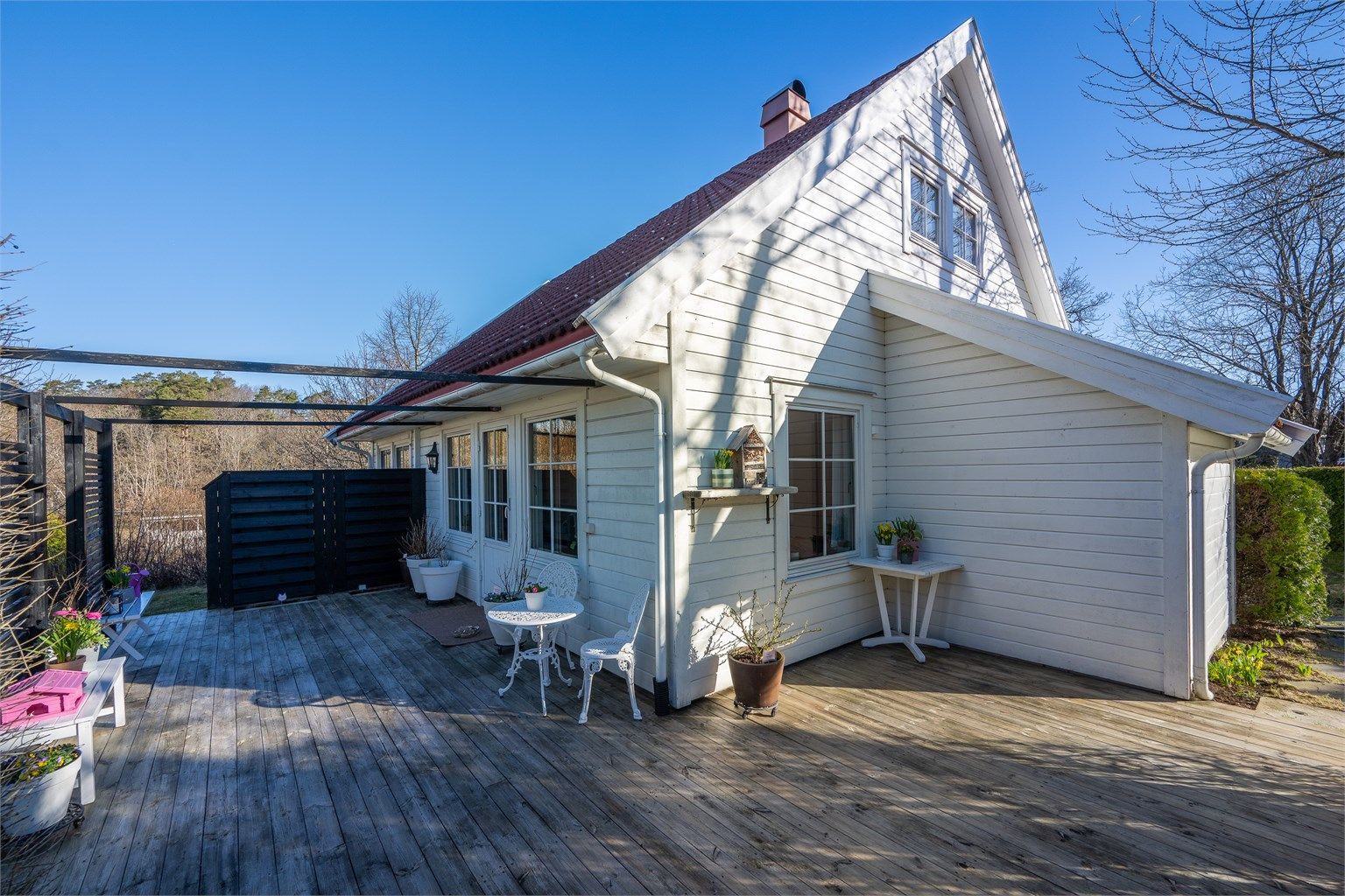 Nyt avslapping på en solrik terrasse med skjerming, rett utenfor stuen