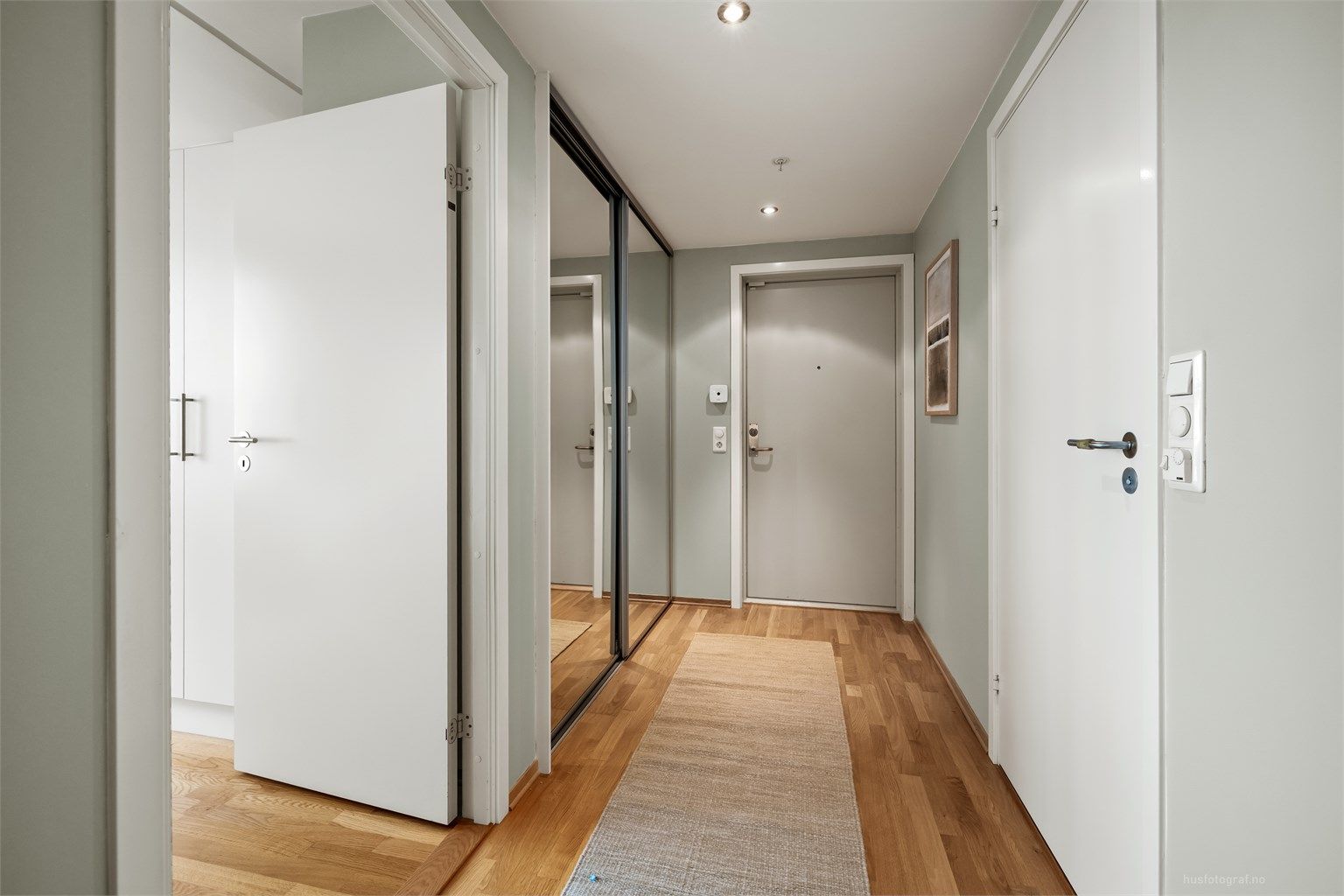 Entré med skyvedørsgarderobe som har speilfronter.