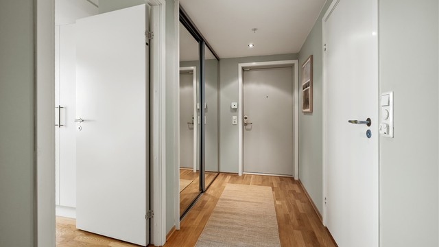 Entré med skyvedørsgarderobe som har speilfronter.