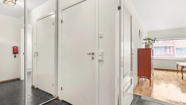 Entré/gang med gulvfliser og skyvedørsgarderobe