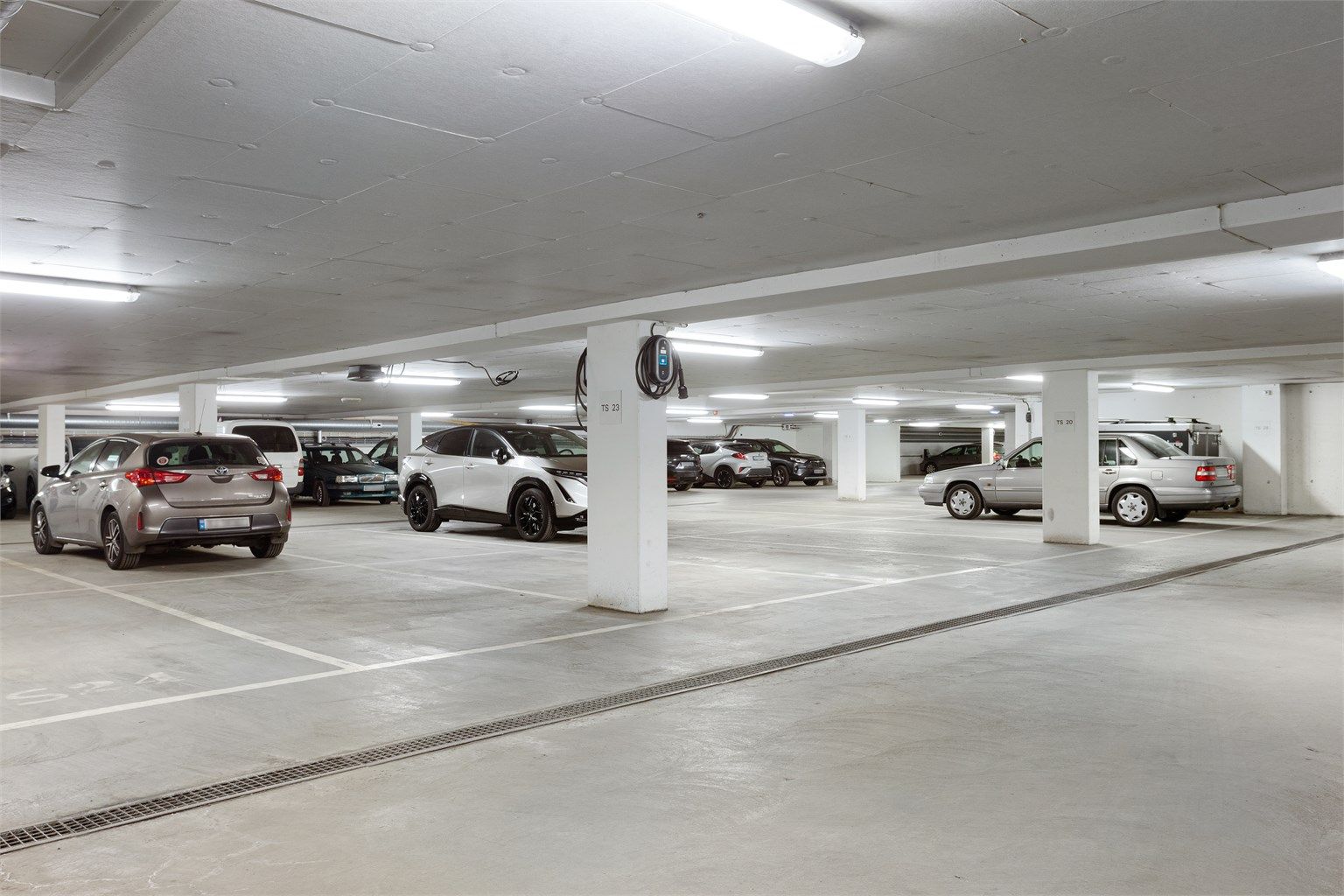 En parkeringsplass i felles garasjekjeller. Parkeringsplassen er tinglyst som en tilleggsdel til seksjonen.