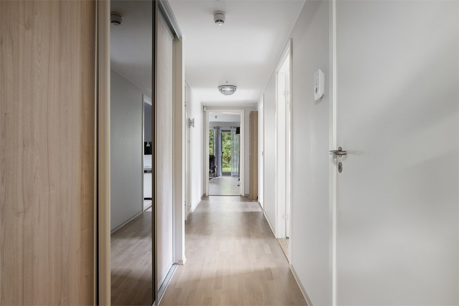 Velkommen inn i en lys og fin entré med skyvedørsgarderobe for oppheng av yttertøy