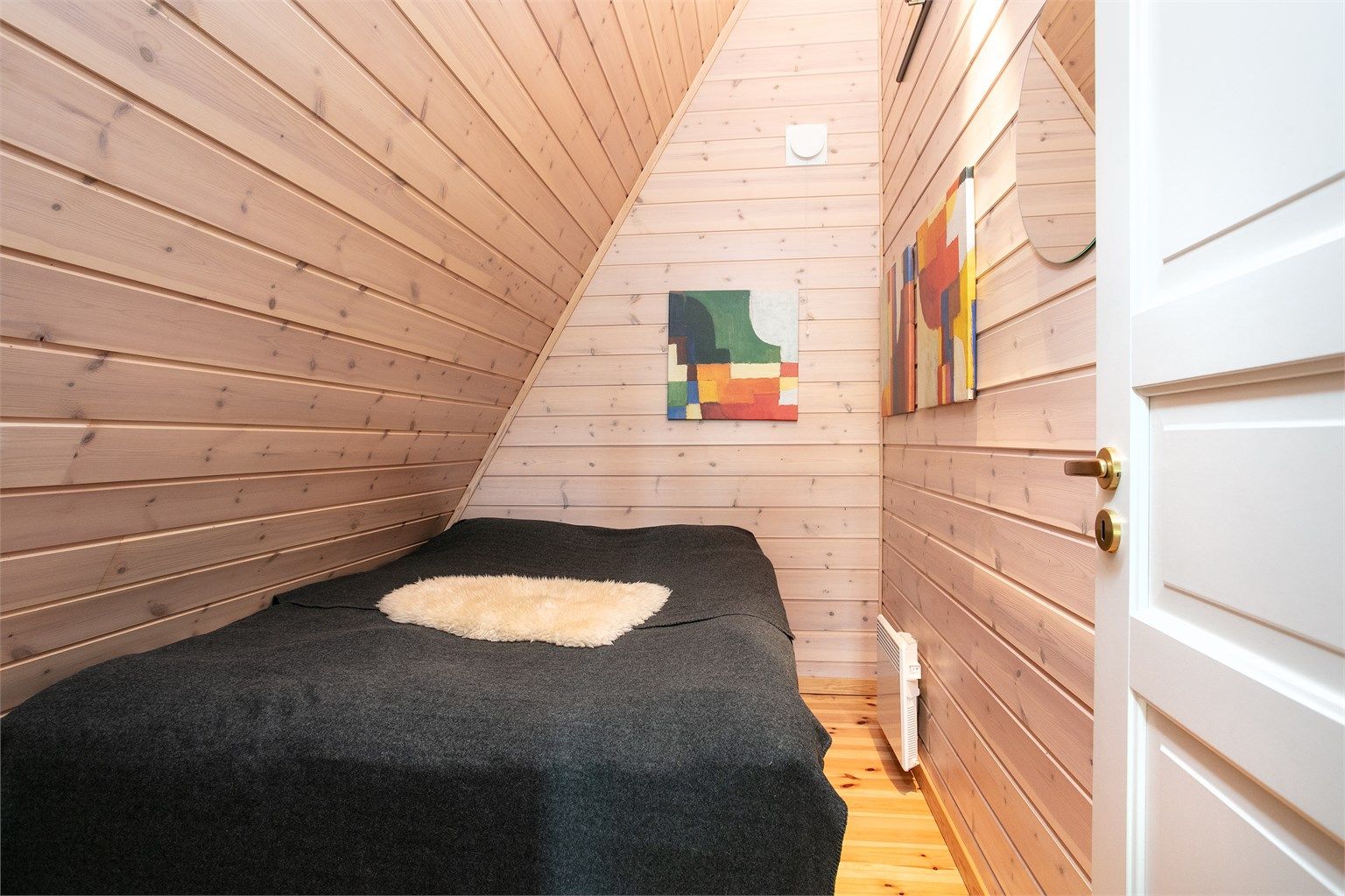 Sovealkove på hemsen med furugulv og panelkledde overflater.