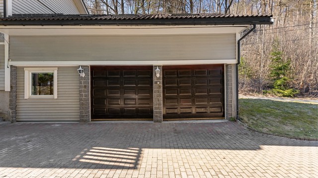 Garasjen er tilliggende boligen, med elektriske leddporter i tre. Rom over garasje er godkjent i kommunen og kjøper overtar ansvaret for dette. Konsekvens er at det må rives.