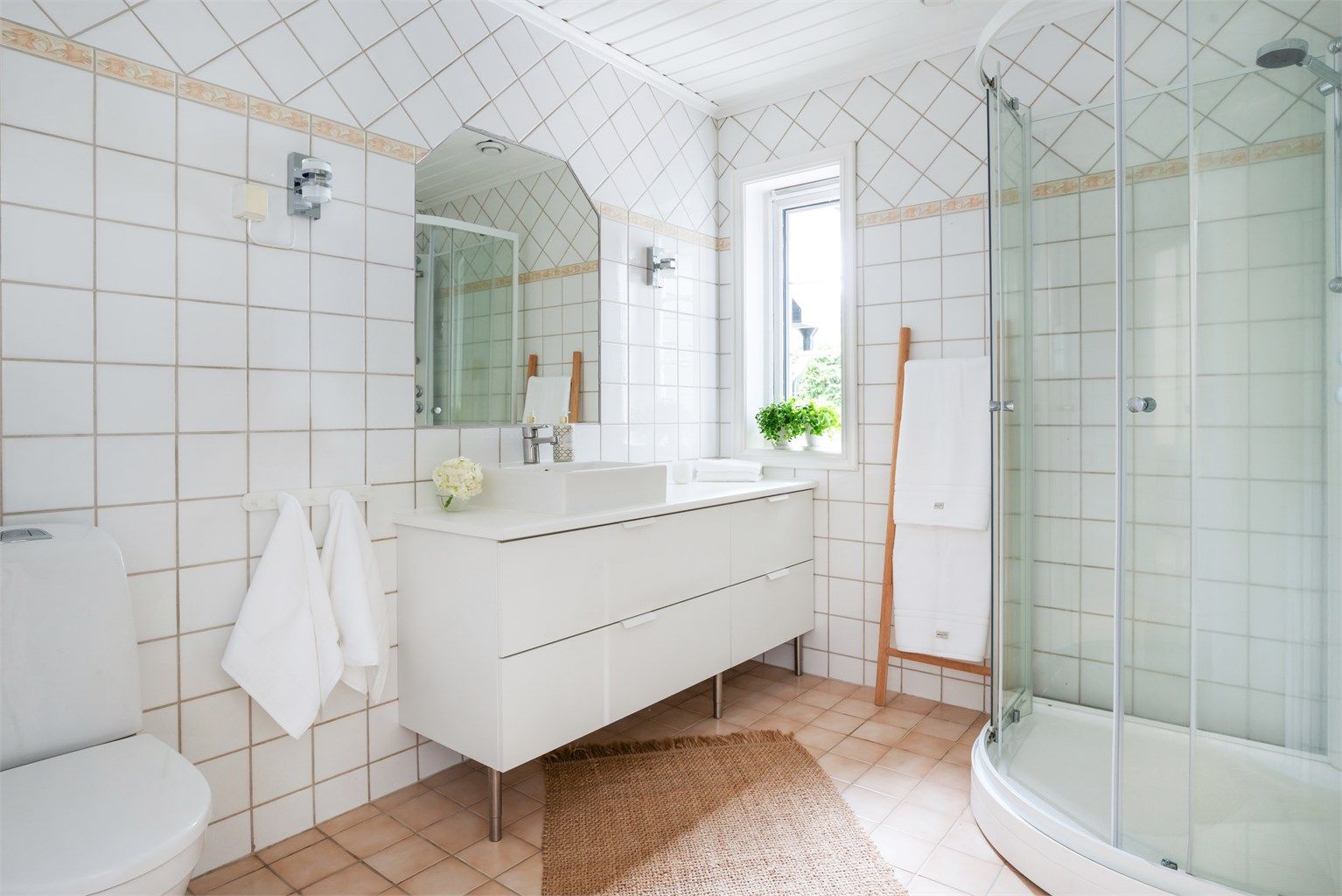 Badet er utstyrt med dusjkabinett (2025), servant med skap og toalett (2024).