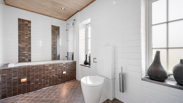 Badet har downlights i taket og et rør-i-rør-system med fordelerskap på veggen.