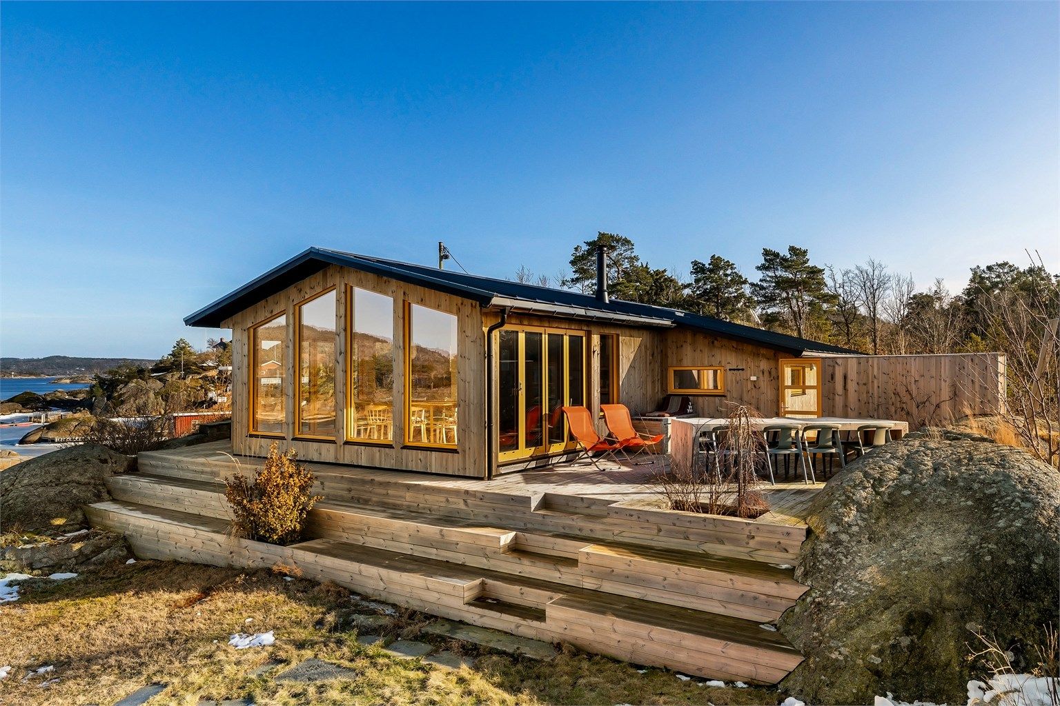 Utvendig er hytta kledd med impregnert trevirke som skal grånes naturlig. Innvendig har arkitekten gått for bjørkefinérplater uten kvist, gulv av eik og betong i en fin kombinasjon.