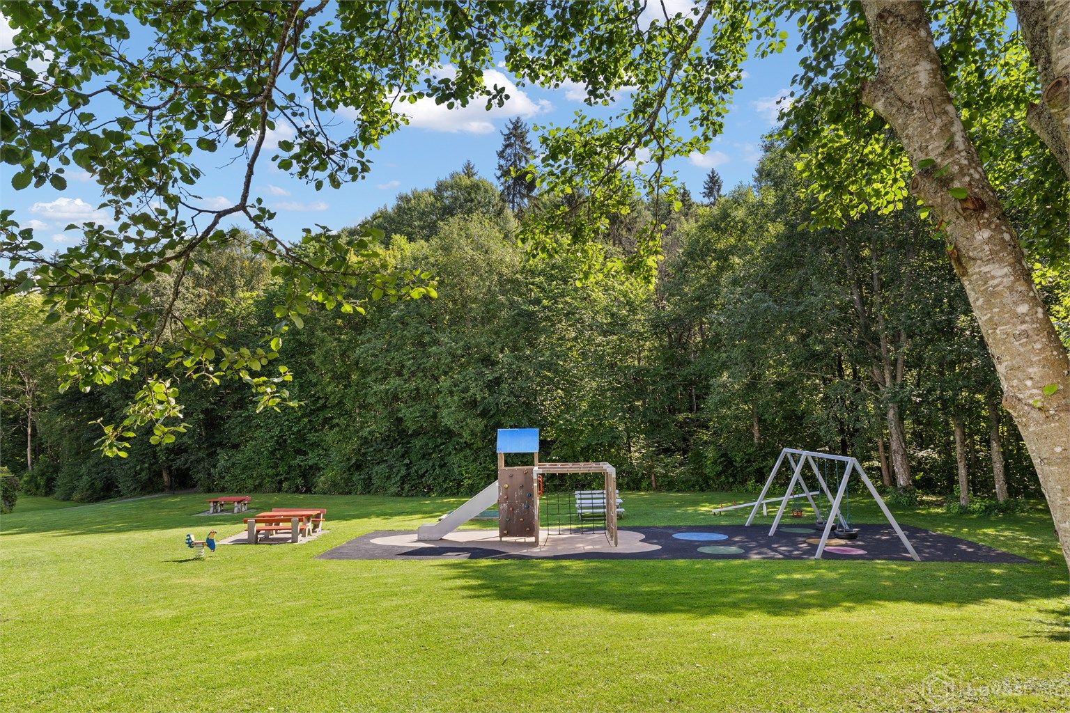 Store, grønne fellesarealer med lekeplass rett utenfor bygget.