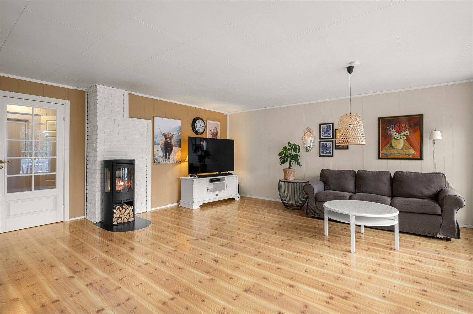 Stuen fremstår som luftig og innbydende, med vedovn som skaper en lun og hyggelig atmosfære gjennom kjøligere dager.