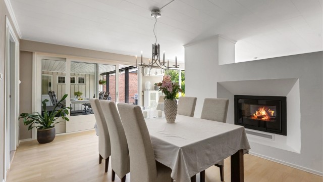 Spisestuen har en peis med glassdør som gir god varme og hygge.