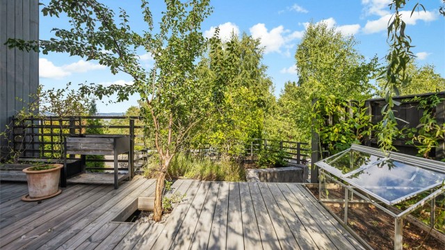 På baksiden av boligen omringet av furutrær finner du en idyllisk terrasse med beplantning, sittegrupper og eget hageareal.
