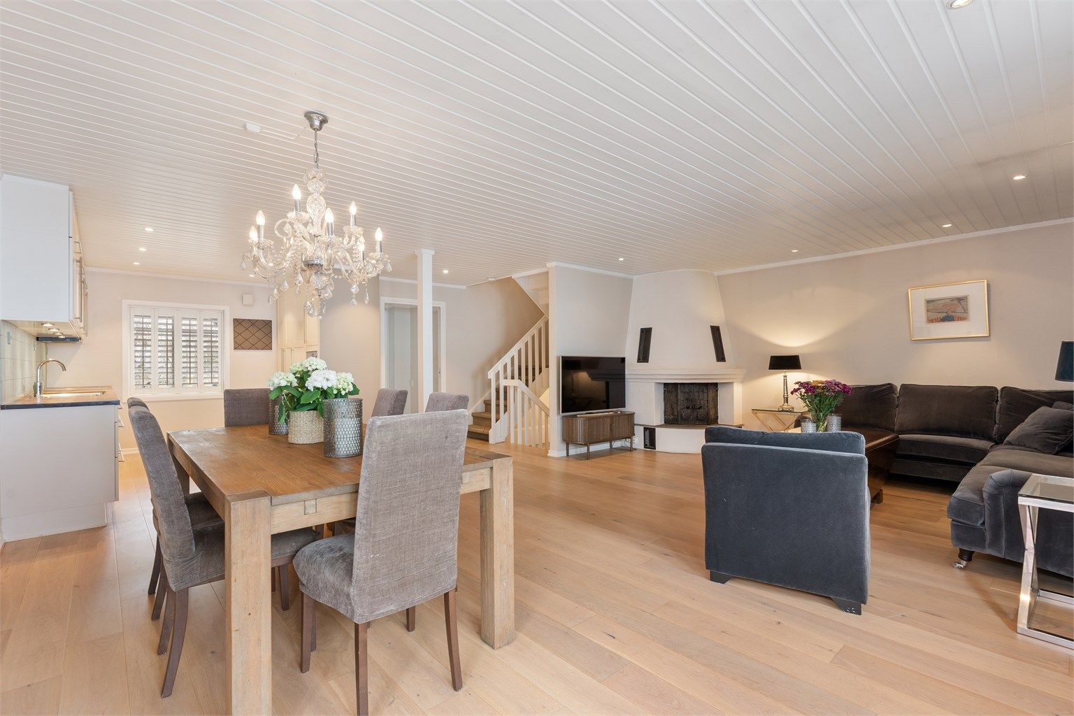 Den åpne løsningen mellom stue, spisestue og kjøkken gir en god flyt i boligens sosiale sone.