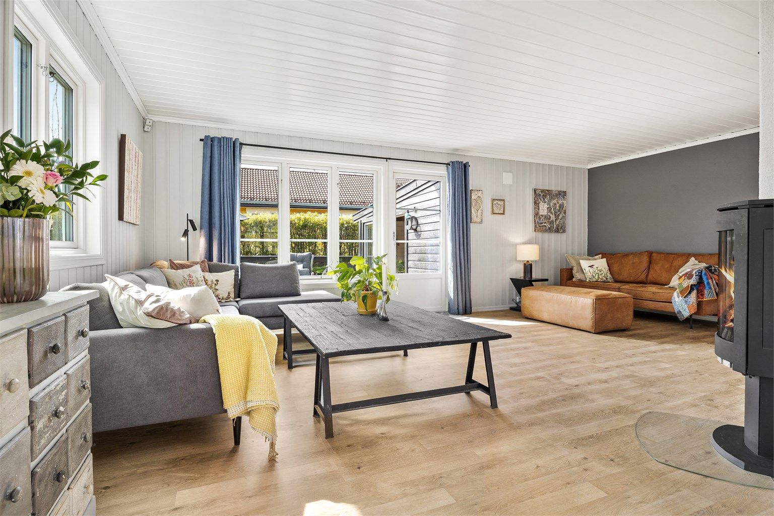 Stuen har god plass til flere sittegrupper og oppleves som romslig.